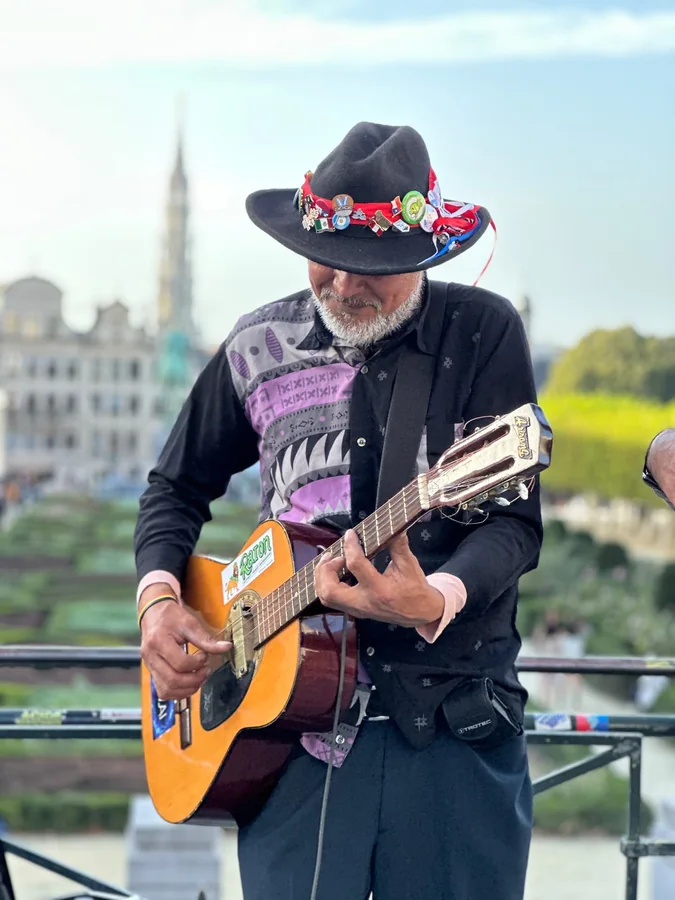 A street musician playing an acoustic guitar outdoors