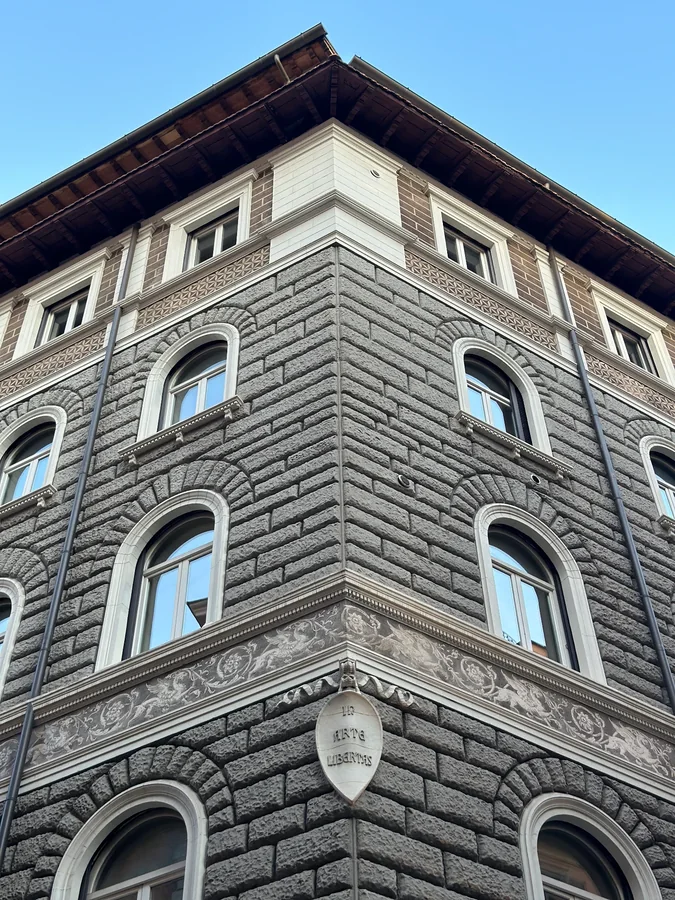 An ornate stone building viewed from its corner against a blue sky