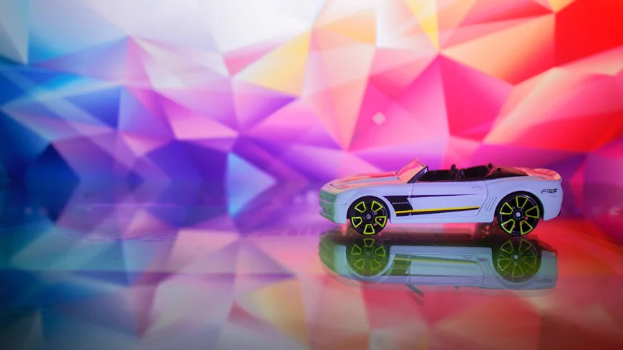A toy convertible reflected against a colourful geometric backdrop