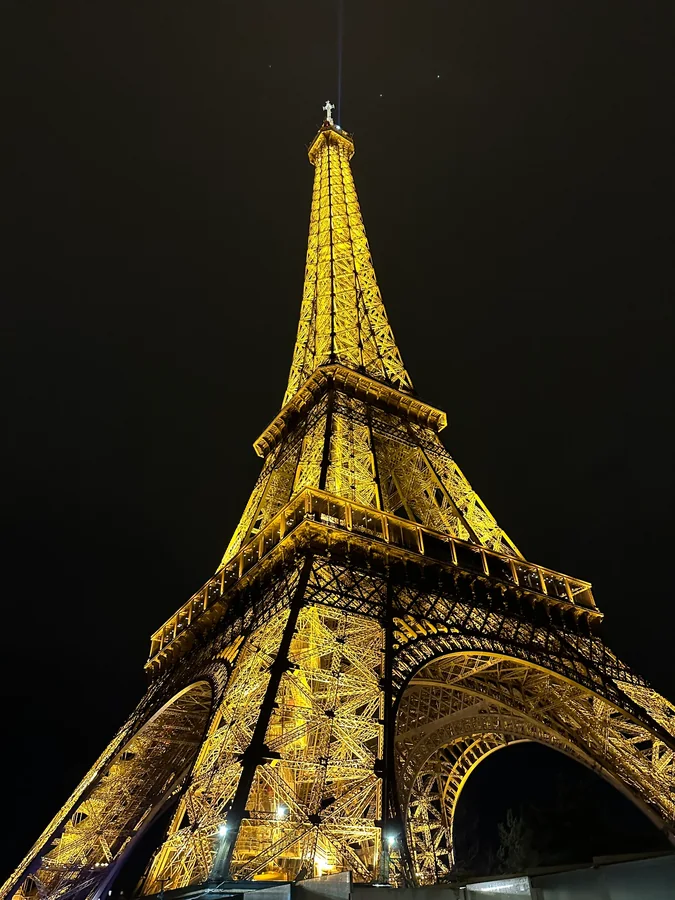 The illuminated Eiffel Tower viewed from below at night